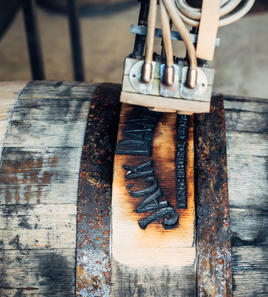 The Jack Daniel's logo being branded onto a barrel.