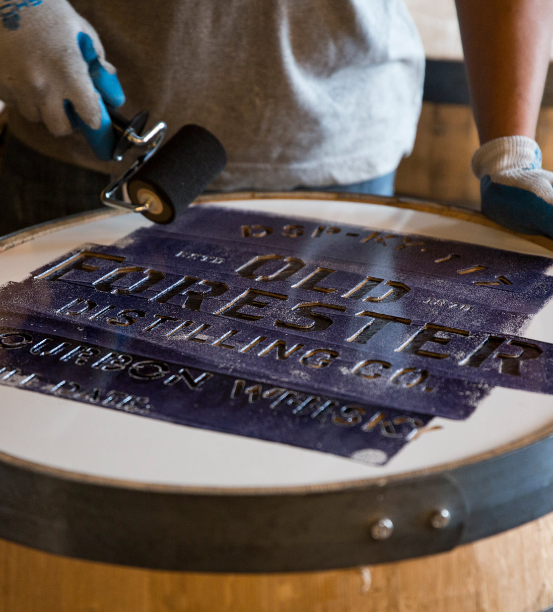 A person rolls ink onto the Old Forester brand.