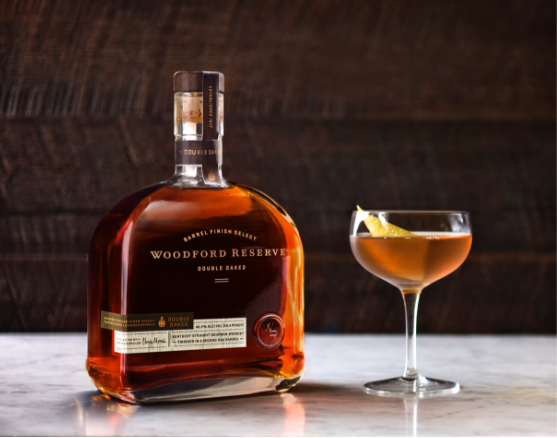 A bottle of Woodford Reserve Double Oaked beside a filled glassed.